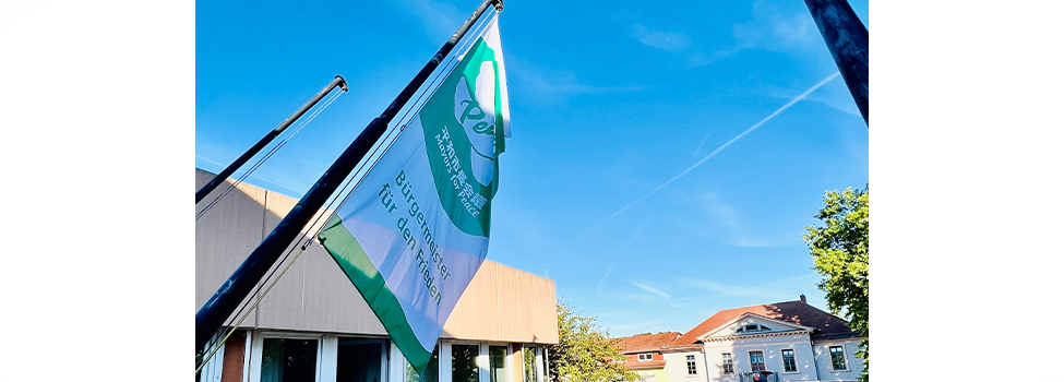 Die Flagge von Mayors for Peace weht vor dem Rathaus der Verbandsgemeinde Nieder-Olm