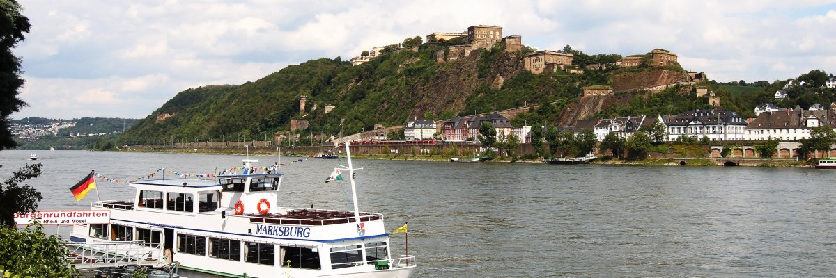 Ein Schiff auf dem Rhein Auf dem Foto erkennt man ein Schiff auf dem Rhein. Im Hintergrund erkennt man eine Burg und steile Weinberge.