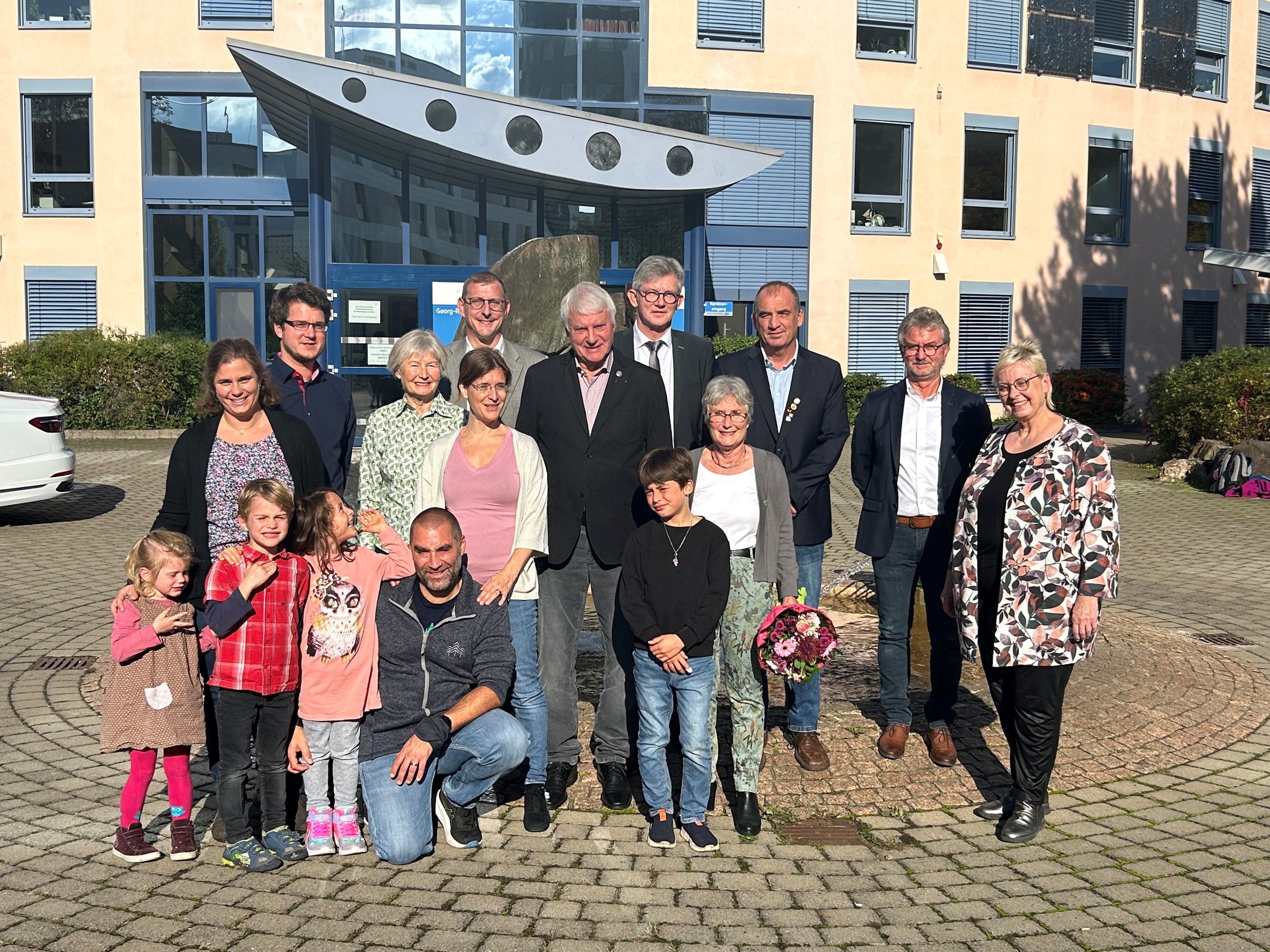 Auf dem Bild erkennt man eine  Gruppe von Menschen die vor der Kreisverwaltung Mainz-Bingen in Ingelheim stehen.