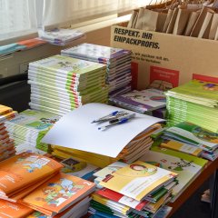 Auf dem Bild erkennt man diverse Schulbücher die auf verschiedenen Stapeln liegen. 