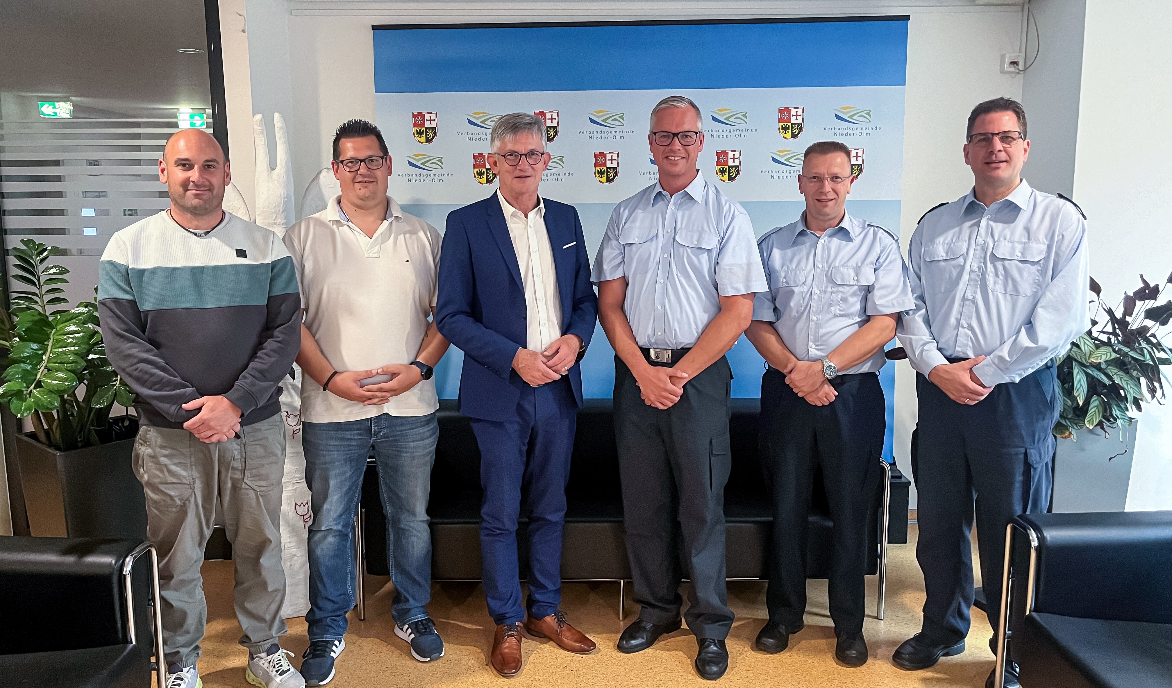 Auf dem Foto erkennt man sechs Personen. In der Mitte, in einem blauen Anzug, steht Bürgermeister Ralph Spiegler. Neben ihm stehen Herren der Feuerwehr in hellblauen Hemden.