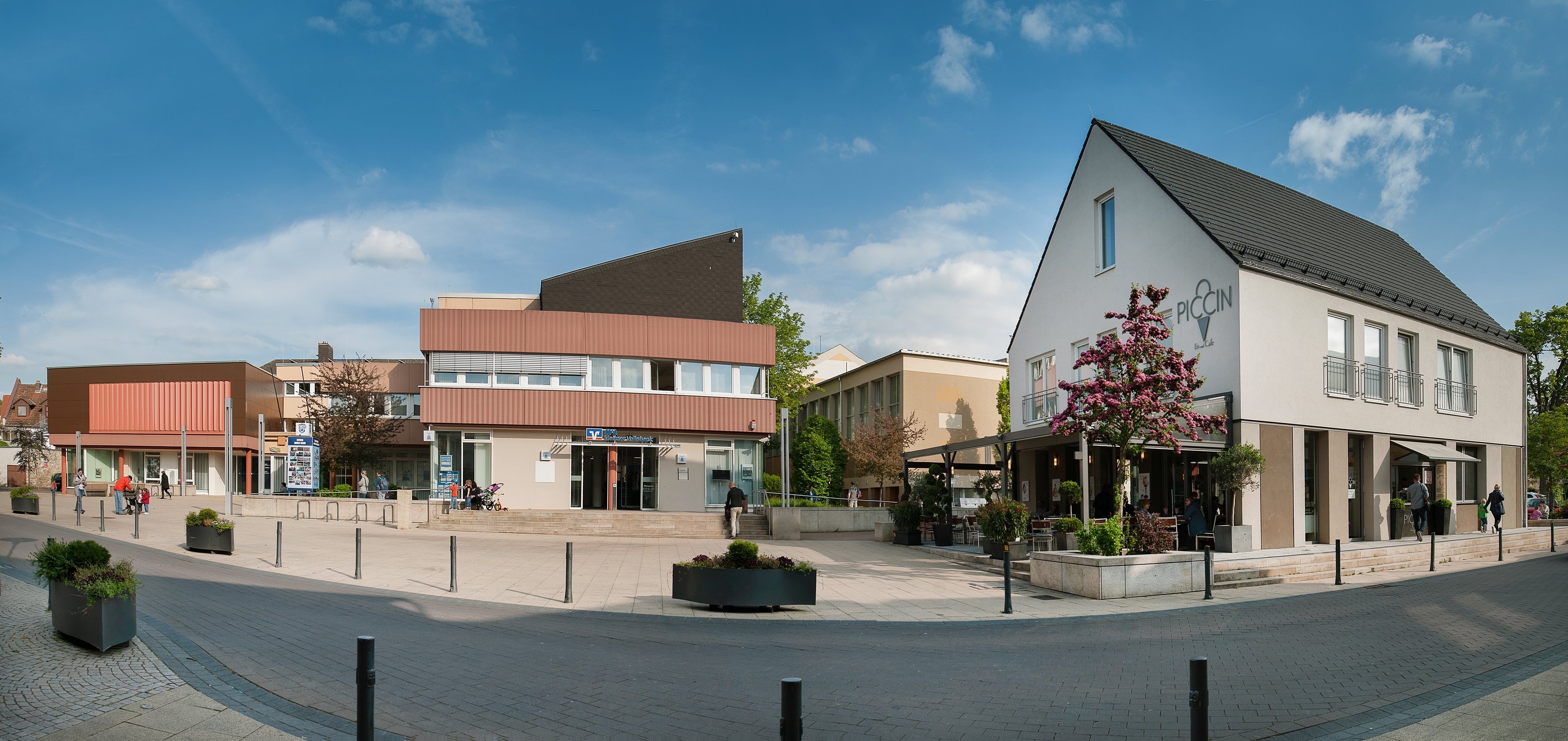 Der Rathausplatz in Nieder-Olm Auf dem Foto erkennt man den Rathausplatz von Nieder-Olm. Links das Rathaus, in der Mitte eine Volksbankfiliale und rechts ein Eiscafé.