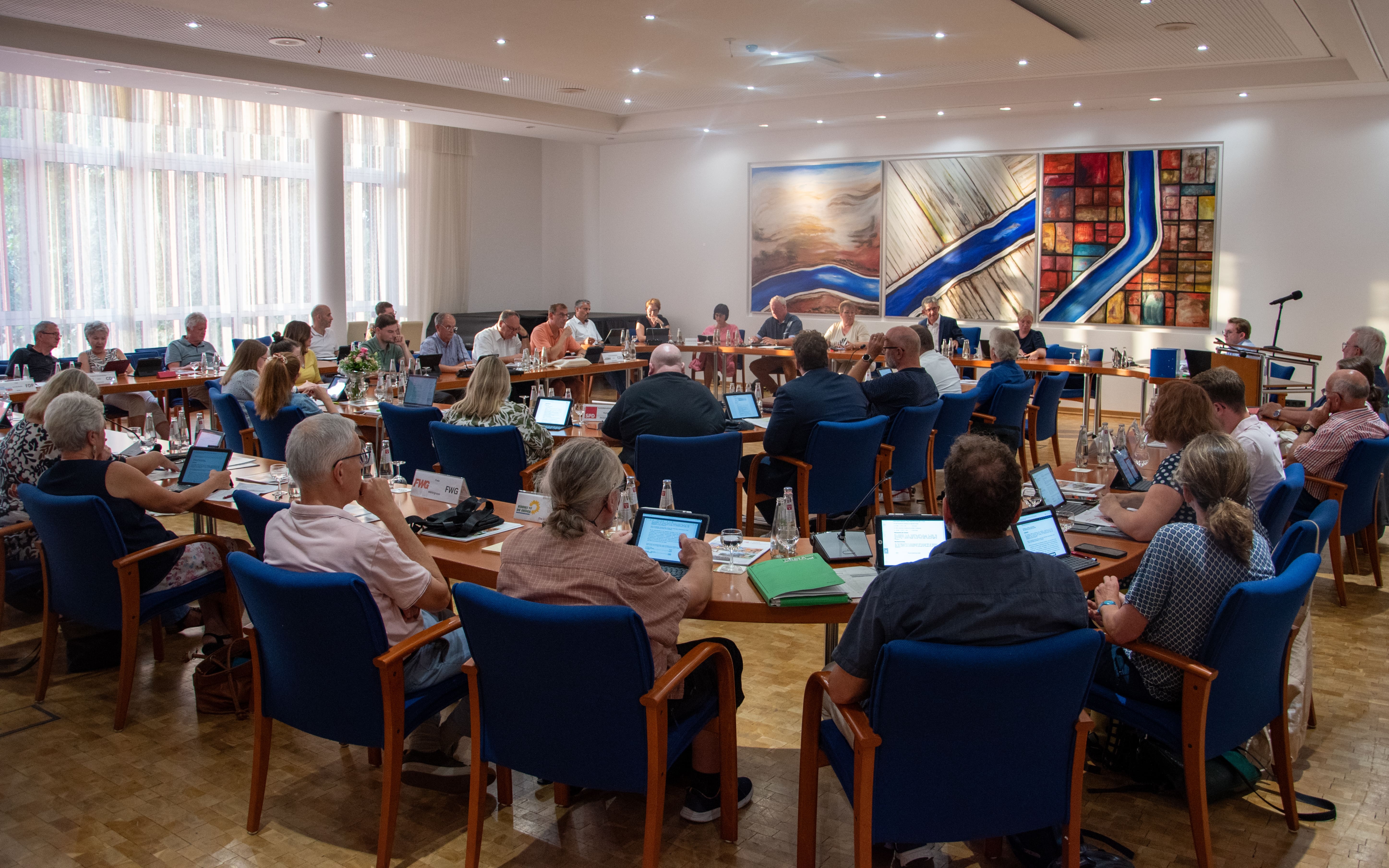 Auf dem Bild erkennt man Menschen, die in einem Stuhlkreis sitzen