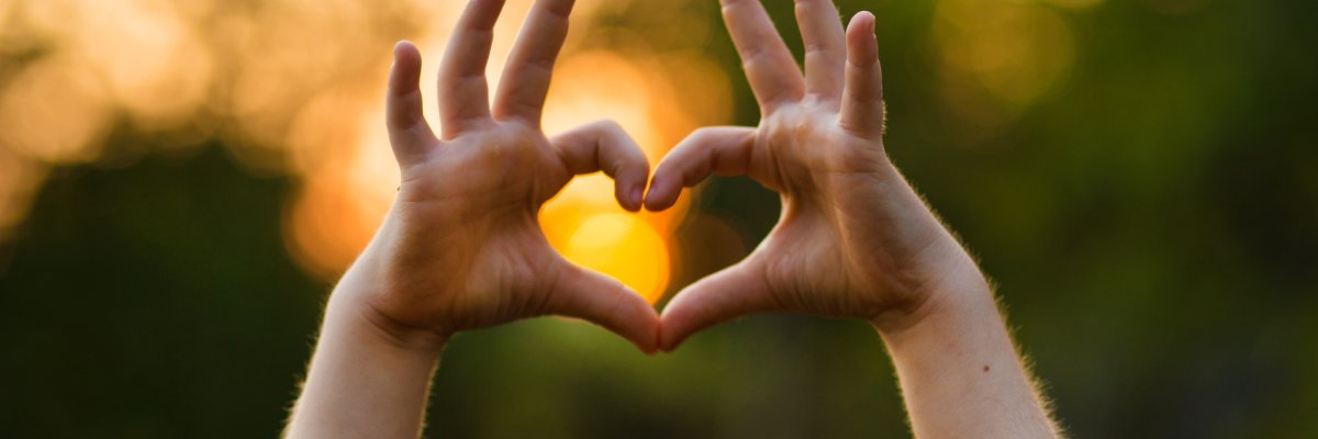 Ein Kind formt mit den Händen ein Herz.