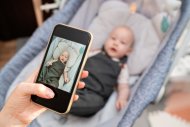 Baby wird mit Smartphone fotografiert