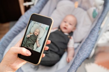 Baby wird mit Smartphone fotografiert
