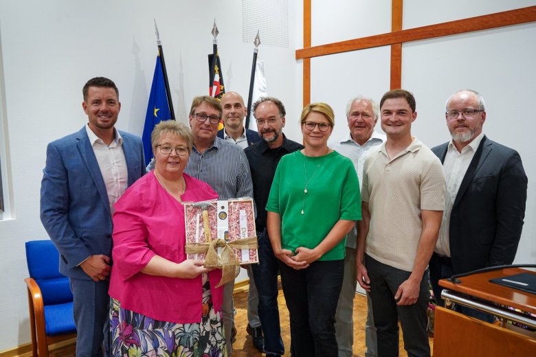 Eine Gruppe von Personen steht im Ratssaal der VG Nieder-Olm