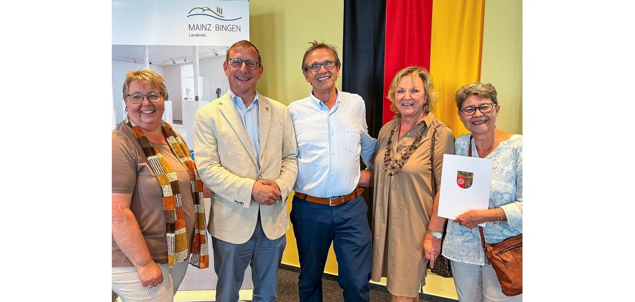 Gruppenfoto Übergabe Kreiszuwendung Eine Gruppe von fünf Menschen schaut und lacht in die Kamera.