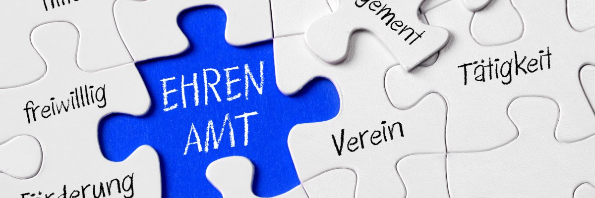 Auf dem Foto erkennt man ein Puzzle. In der Mitte ist ein blaues, freies Feld, in welchem "Ehrenamt" steht. Drum Herum stehen Begriffe wie sozial, Verein, Gemeinde, Tätigkeit.