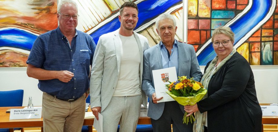 Vier Personen stehen nebeneinander und lachen freudig in die Kamera