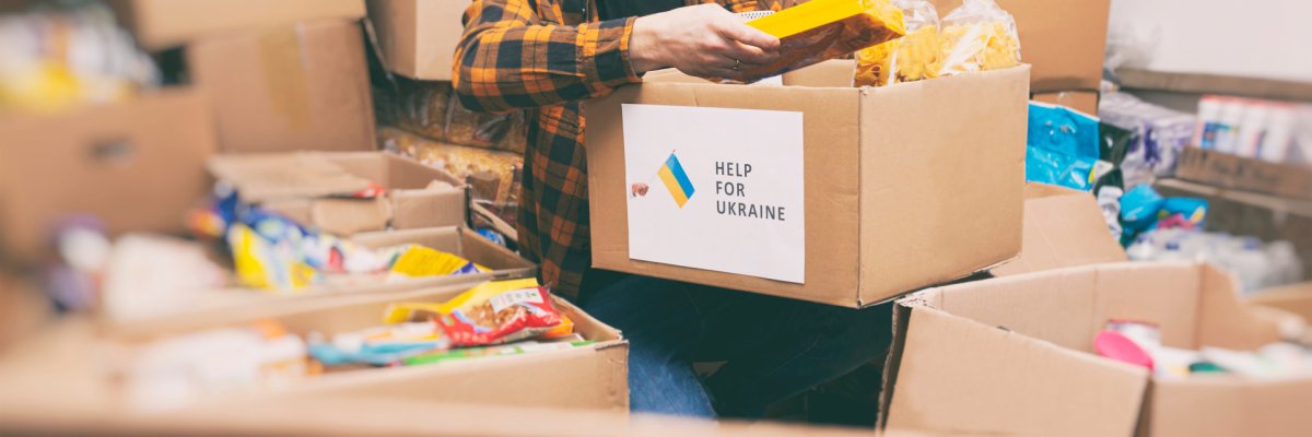 Auf dem Foto erkennt man eine Menge Kartons. Zentral ist ein Karton zu sehen, auf welchem "Help for Ukraine" geschrieben steht